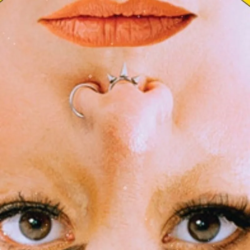 An upside-down close-up of a face with a nose ring