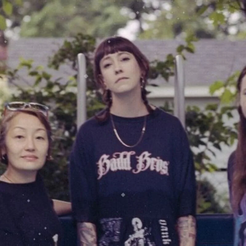 Members of Penny & The Pits standing in a backyard