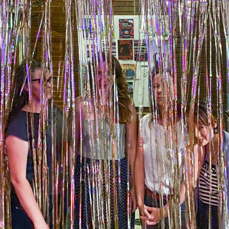 The four members of Shoulder Season behind a tinsel curtain
