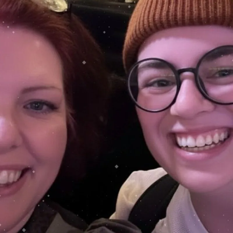 The two members of We, Cassie smiling in a selfie