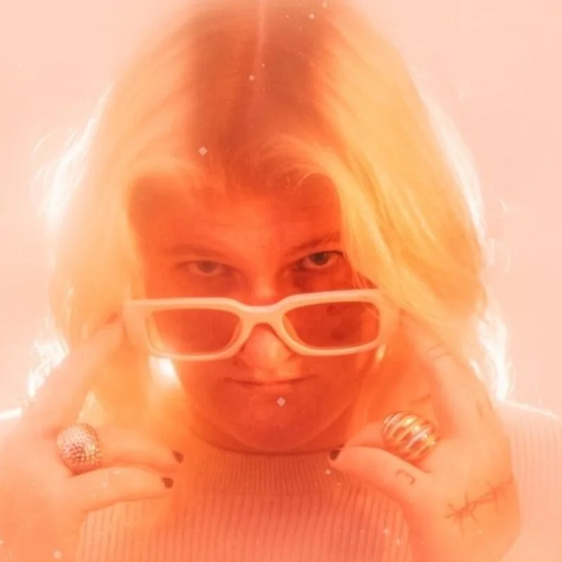Burry in white sunglasses, lit in soft orange light