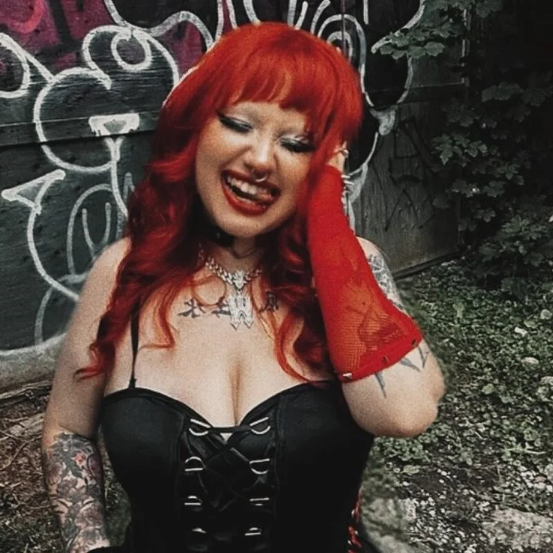 Warlet laughing in front of a graffiti wall