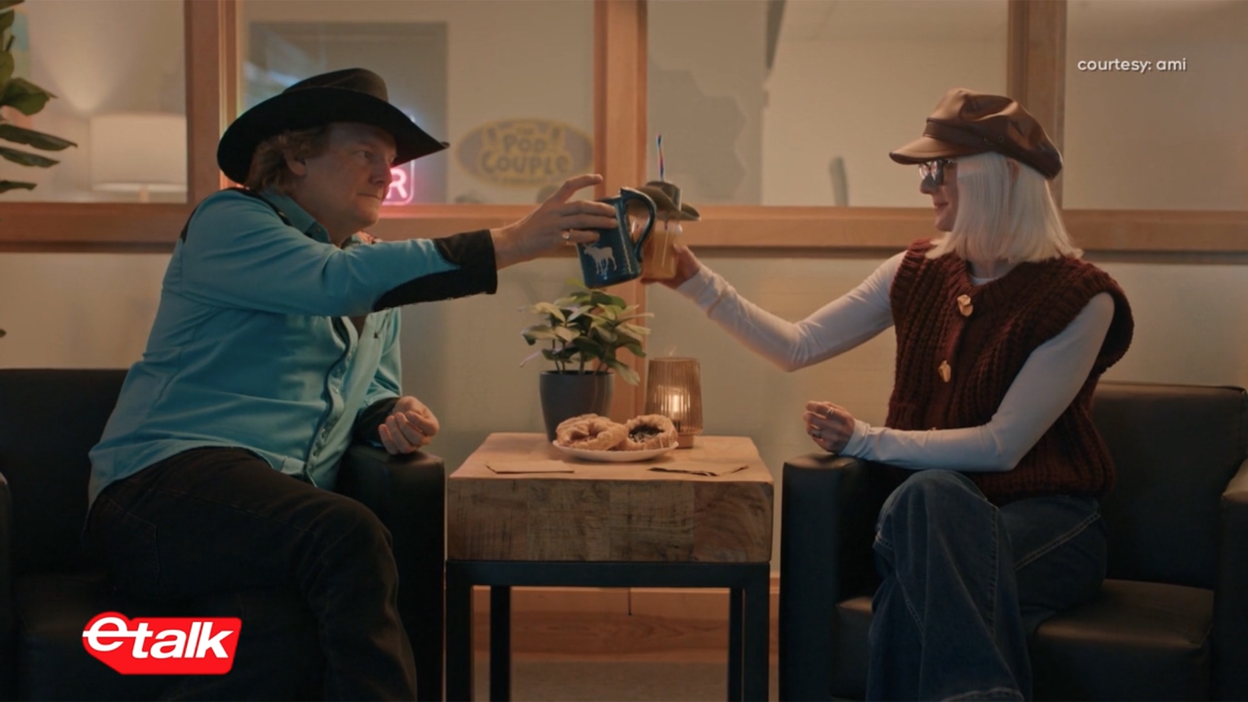 Jonathan Torrens and Jennie Bovard in cowboy hats raising mugs in a Pretty Blind scene featured on Etalk
