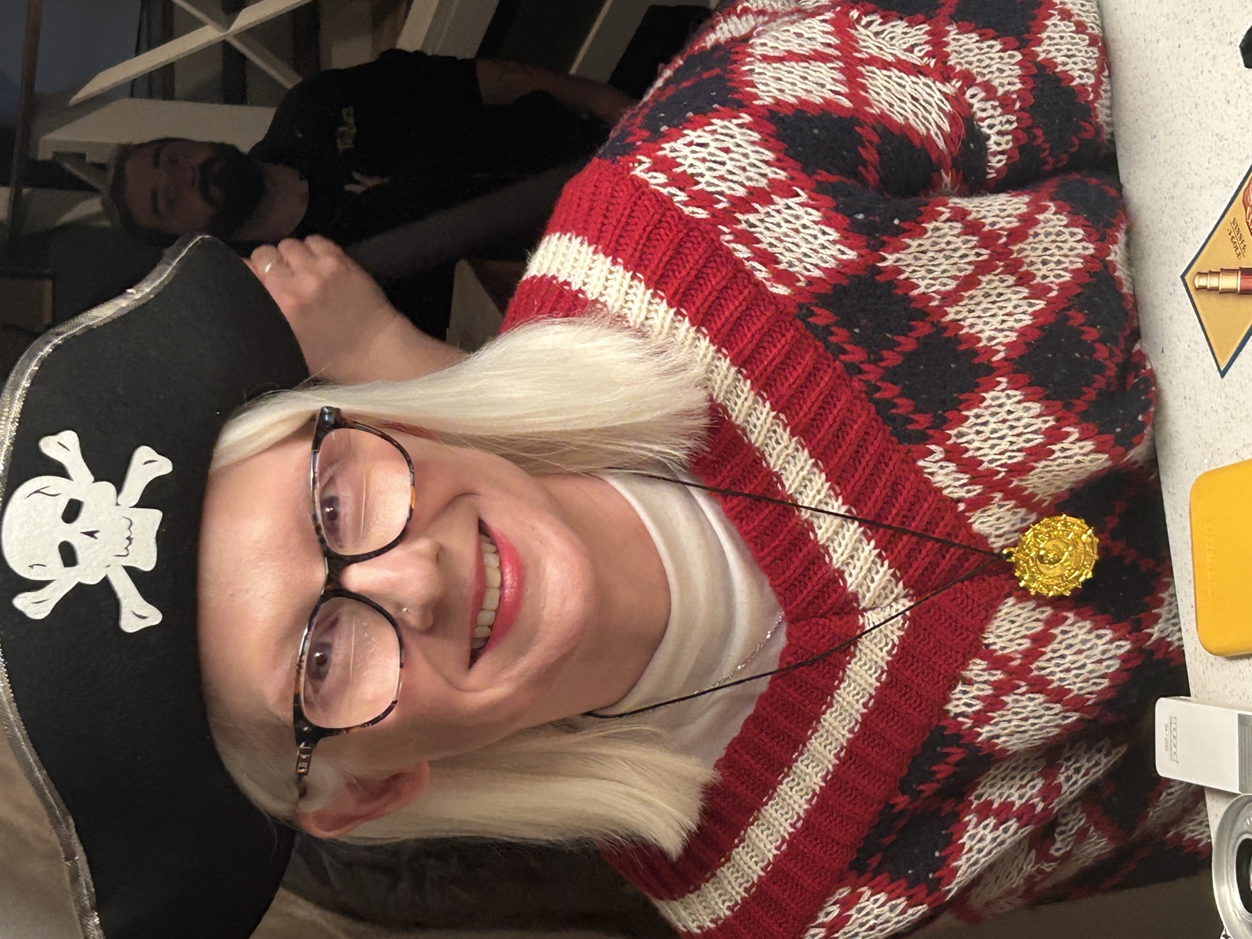 Jennie Bovard smiling in a pirate hat while playing a board game on the Pretty Blind set