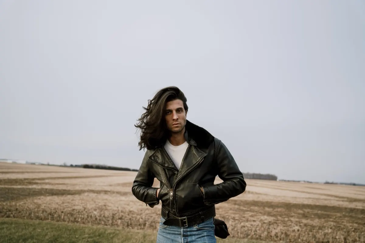 Billy Raffoul in a leather jacket in an open field