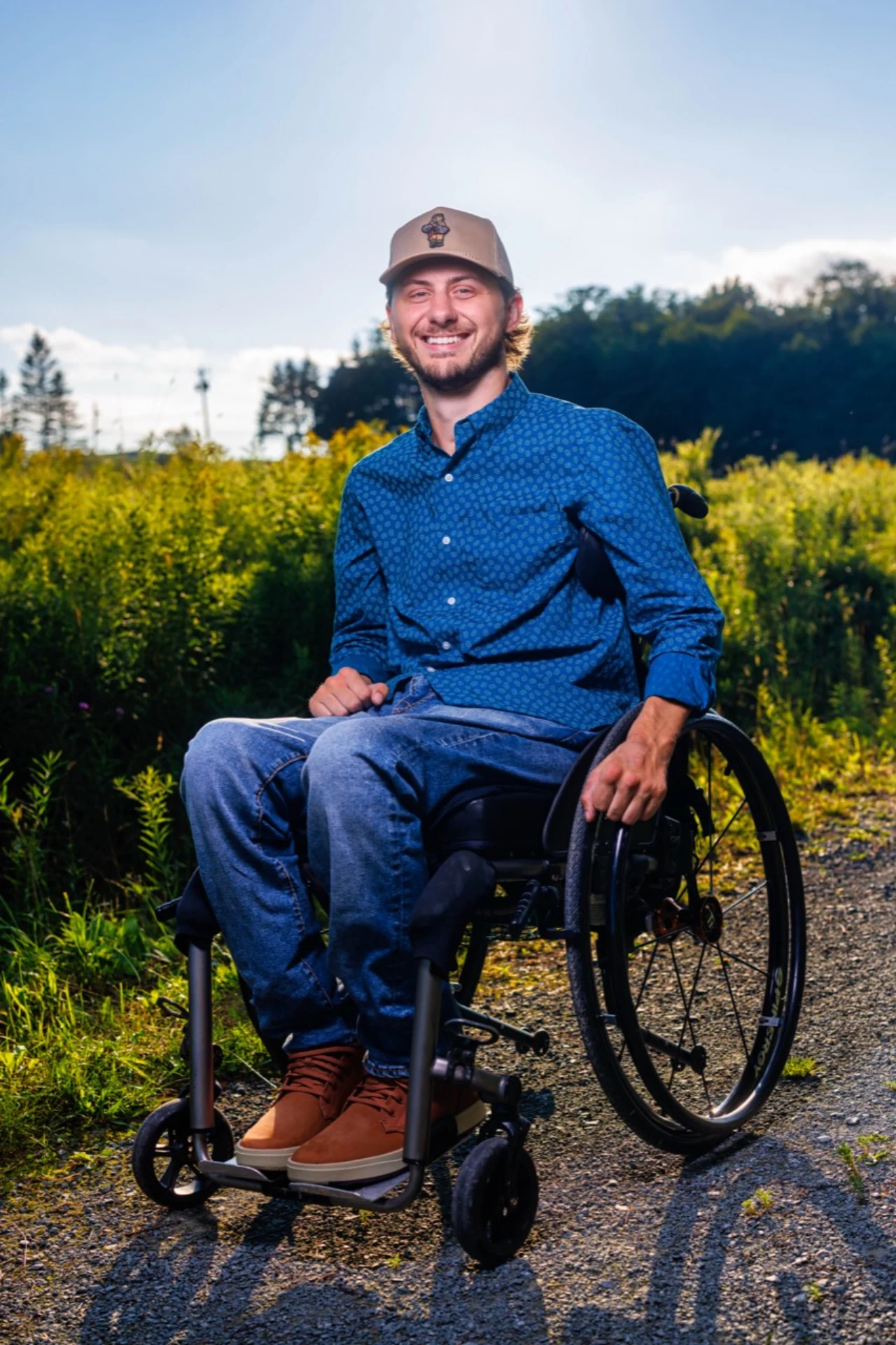 Connor Hirtle smiling outdoors while seated in his wheelchair